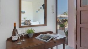 A wooden desk with a wine bottle, two glasses, a magazine, and a potted plant.