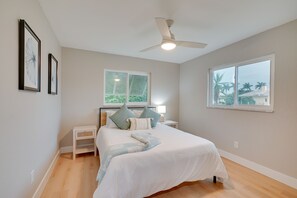A bedroom with a bed, a nightstand, a window, and a ceiling fan. - Cape Coral Home w/ Pool & Boat Dock, 5 Mi to Beach (Cape Coral)
