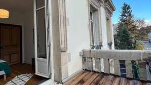 A wooden deck with a view of a building's exterior. - Apartment 'L'aristide' with Private Terrace, Balcony and Wi-Fi (EPINAL)