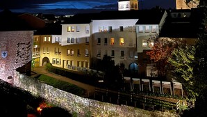 A historic building with a tower, a courtyard with a fountain, and a stone wall. - Apartment 'L'aristide' with Private Terrace, Balcony and Wi-Fi (EPINAL)