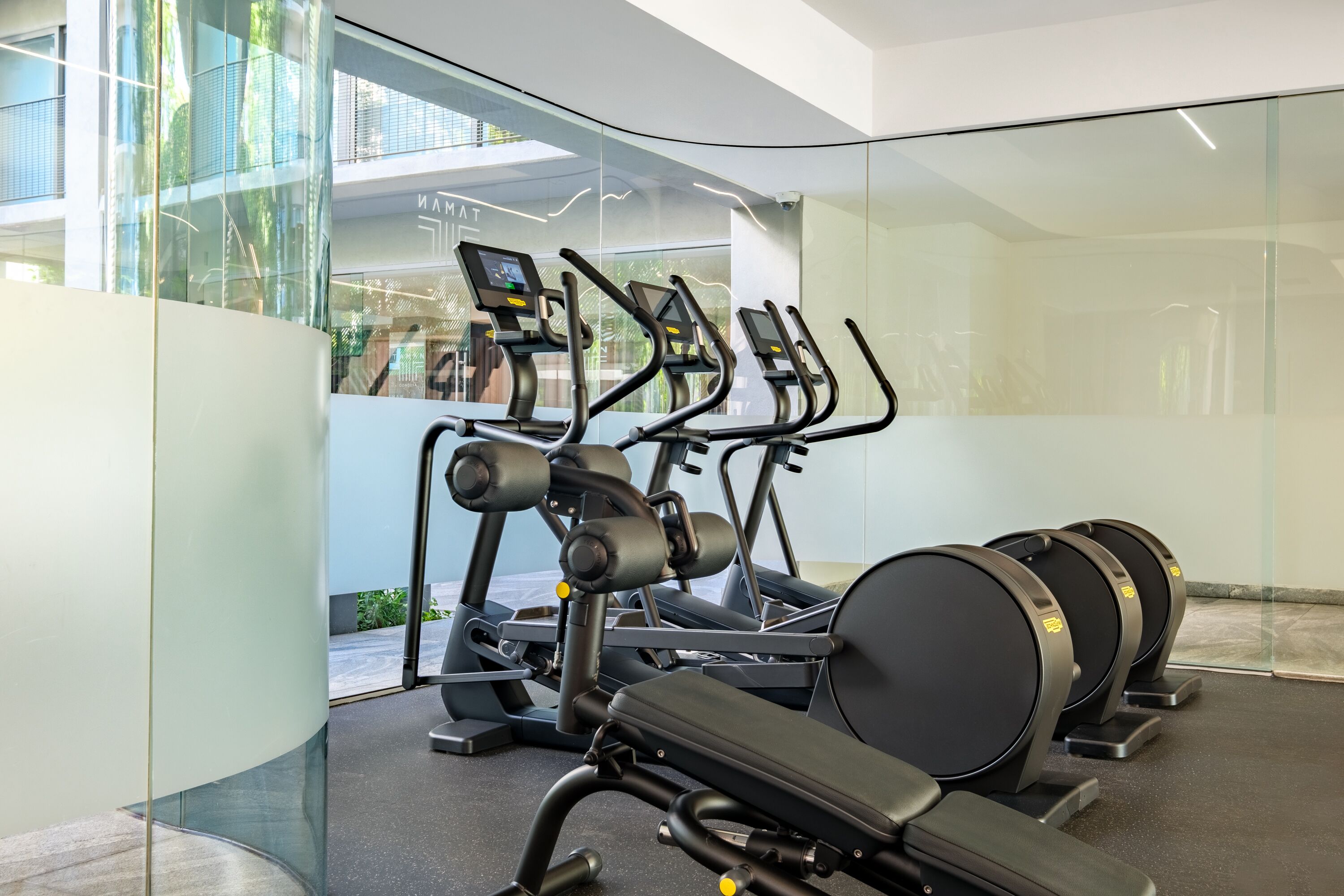 Un gimnasio moderno con cintas de correr y elípticas.