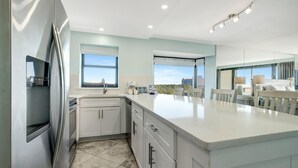 A modern kitchen with a large island, stainless steel appliances, and large windows providing natural light. - Modern Luxury, Gulf Views: Renovated 5th-Floor Oasis at Sandestin Golf and Beach Resort! (Miramar Beach)