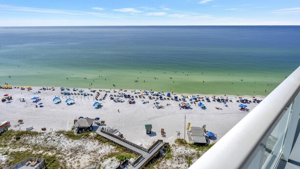 A beach with umbrellas and people, a clear sky, and a view of the ocean. - Sky-High Serenity: 15th-Floor Studio Retreat with Unobstructed Gulf Views at Sandestin Golf and Beach Resort! (Miramar Beach)
