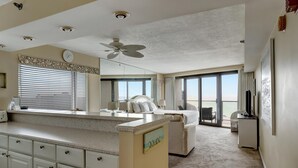 A spacious room with a large bed, a desk, and a view of the ocean. - Sky-High Serenity: 15th-Floor Studio Retreat with Unobstructed Gulf Views at Sandestin Golf and Beach Resort! (Miramar Beach)