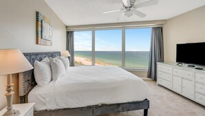 A bedroom with a large bed, a ceiling fan, a TV, and a view of the beach. - "Beachside Serenity: 9th-Floor 1-Bedroom Condo with Gulf Views, Sleeps 4!" at Sandestin Golf and Beach Resort! (Miramar Beach)