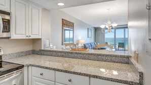 A kitchen with granite countertops, white cabinetry, and a built-in oven. - "Beachside Serenity: 9th-Floor 1-Bedroom Condo with Gulf Views, Sleeps 4!" at Sandestin Golf and Beach Resort! (Miramar Beach)