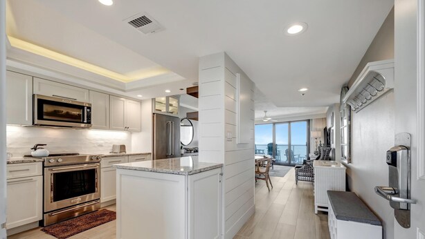 A modern kitchen with stainless steel appliances, a central island, and a view to the living area. - "Unrivaled Luxury: Premier 11th-Floor Beachfront Bliss with Gulf Views!" at Sandestin Golf and Beach Resort! (Miramar Beach)