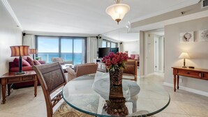 A modern hotel room with a glass dining table, a sofa, a TV, and a balcony with a view. - "Serene Sunrises Await: Inviting 14th-Floor 1-Bedroom Retreat in Beachside Two!" at Sandestin Golf and Beach Resort! (Miramar Beach)