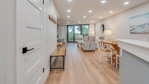 Un intérieur moderne avec un plancher en bois, un coin repas avec des chaises à motifs, un banc et une table.