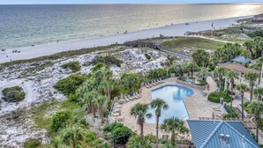 Ein Strandresort mit Pool, Palmen und Blick aufs Meer.