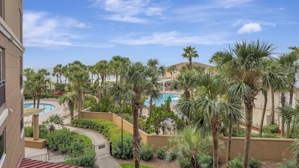 A resort with a pool, palm trees, and a clear sky. - 2BR Beachfront Condo w/ Gulf Views, Golf Cart, Amenities! (Miramar Beach)
