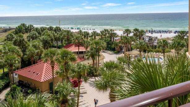 Ein Resort mit Blick auf einen Strand, Palmen und einem Poolbereich.