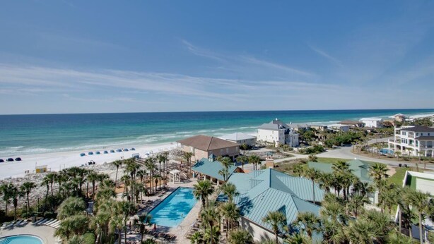 Un resort con piscina, playa y vista al océano.