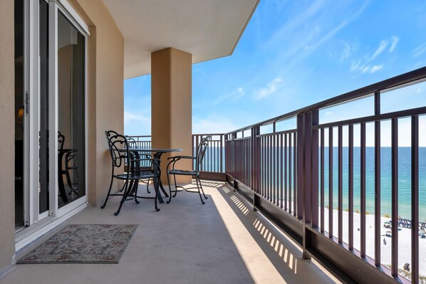 A balcony with a table and chairs, a view of the ocean, and a railing. - "Sunset Splendor: West-Facing 3-Bed, 3-Bath Oasis on the 9th Floor at Westwinds" at Sandestin Golf and Beach Resort! (Miramar Beach)
