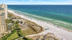 A beach resort with a long sandy beach, a boardwalk, and a high-rise building with balconies. - "19th-Floor Elegance: Newly Refurnished 3-Bed, 3-Bath Condo of Westwinds with Sweeping Gulf Views" at Sandestin Golf and Beach Resort! (Miramar Beach)