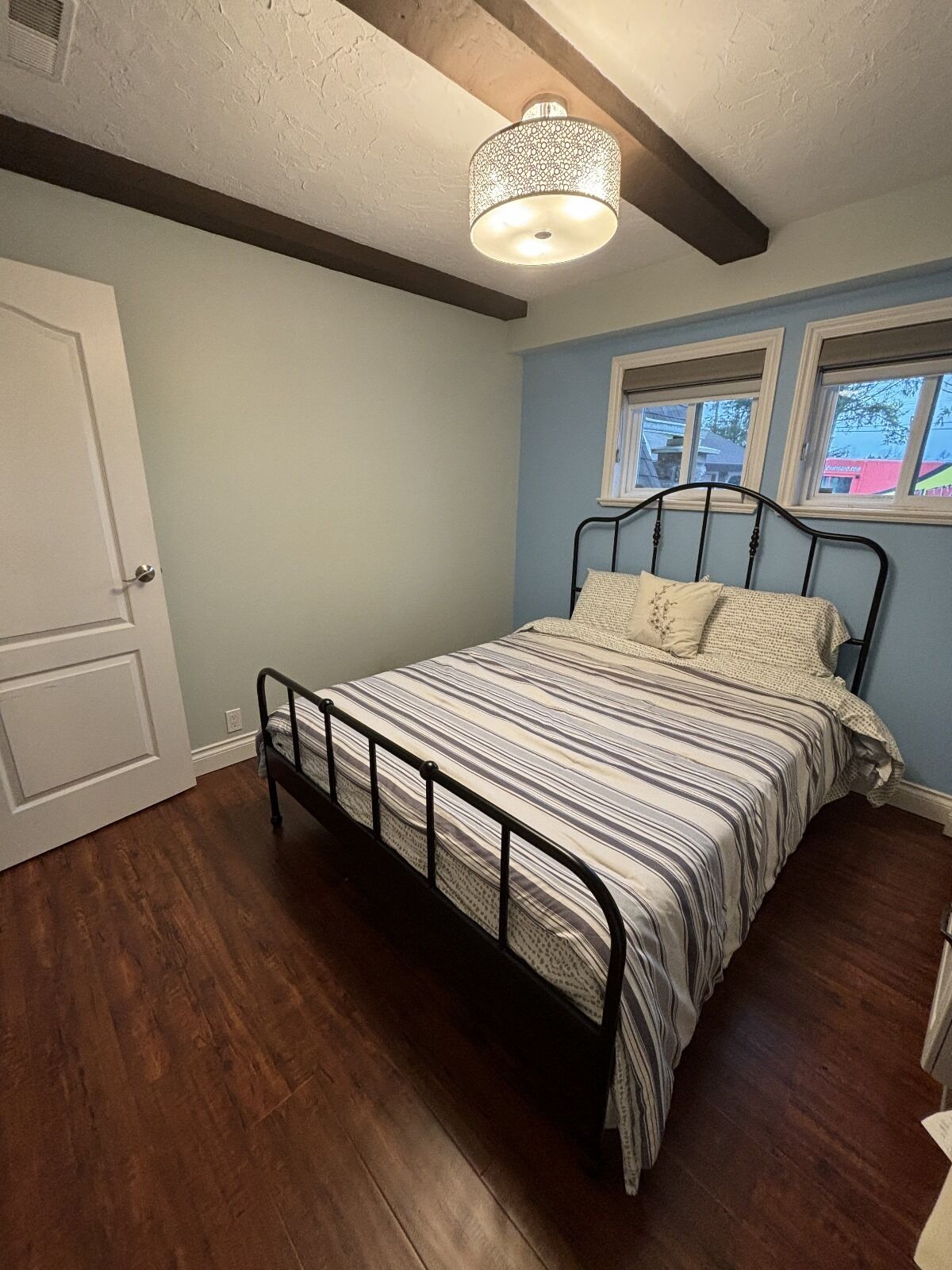 Un dormitorio con una cama, una ventana y una puerta.
