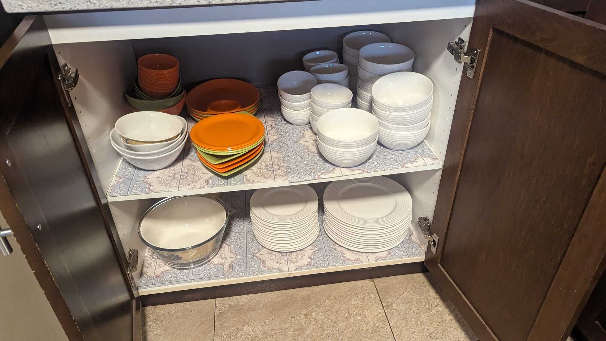 Un meuble de cuisine doté de plusieurs étagères où sont empilées des assiettes et des bols.