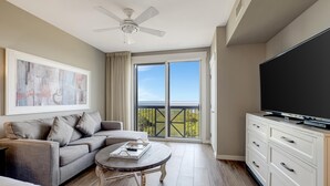 Ein modernes Wohnzimmer mit Sofa, Couchtisch und Flachbildfernseher.