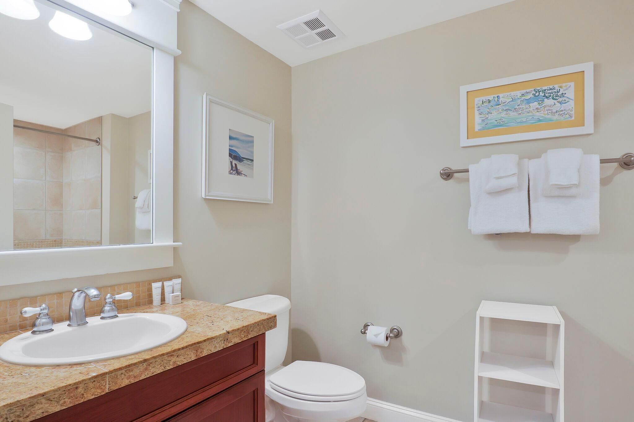 A bathroom with a sink, toilet, and a towel rack with towels.