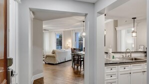 A modern kitchen with white cabinetry, a granite countertop, and a built-in sink. - Distinctive 2nd Floor w/ King Bed, Bonus Room w/ Bunks at Sandestin Golf and Beach Resort! (Miramar Beach)
