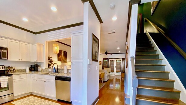 A modern kitchen with white cabinets, a dishwasher, and a granite countertop. - Townhouse in the West End steps from everything! Main St, Falls Park, Baseball  (Greenville)