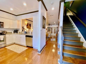 A spacious kitchen with white cabinets, a dishwasher, and a granite countertop.