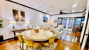 A modern living room with a round dining table, yellow chairs, and a sofa. - Townhouse in the West End steps from everything! Main St, Falls Park, Baseball  (Greenville)