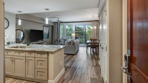Una cocina moderna con una isla grande, electrodomésticos integrados y un comedor con vistas.