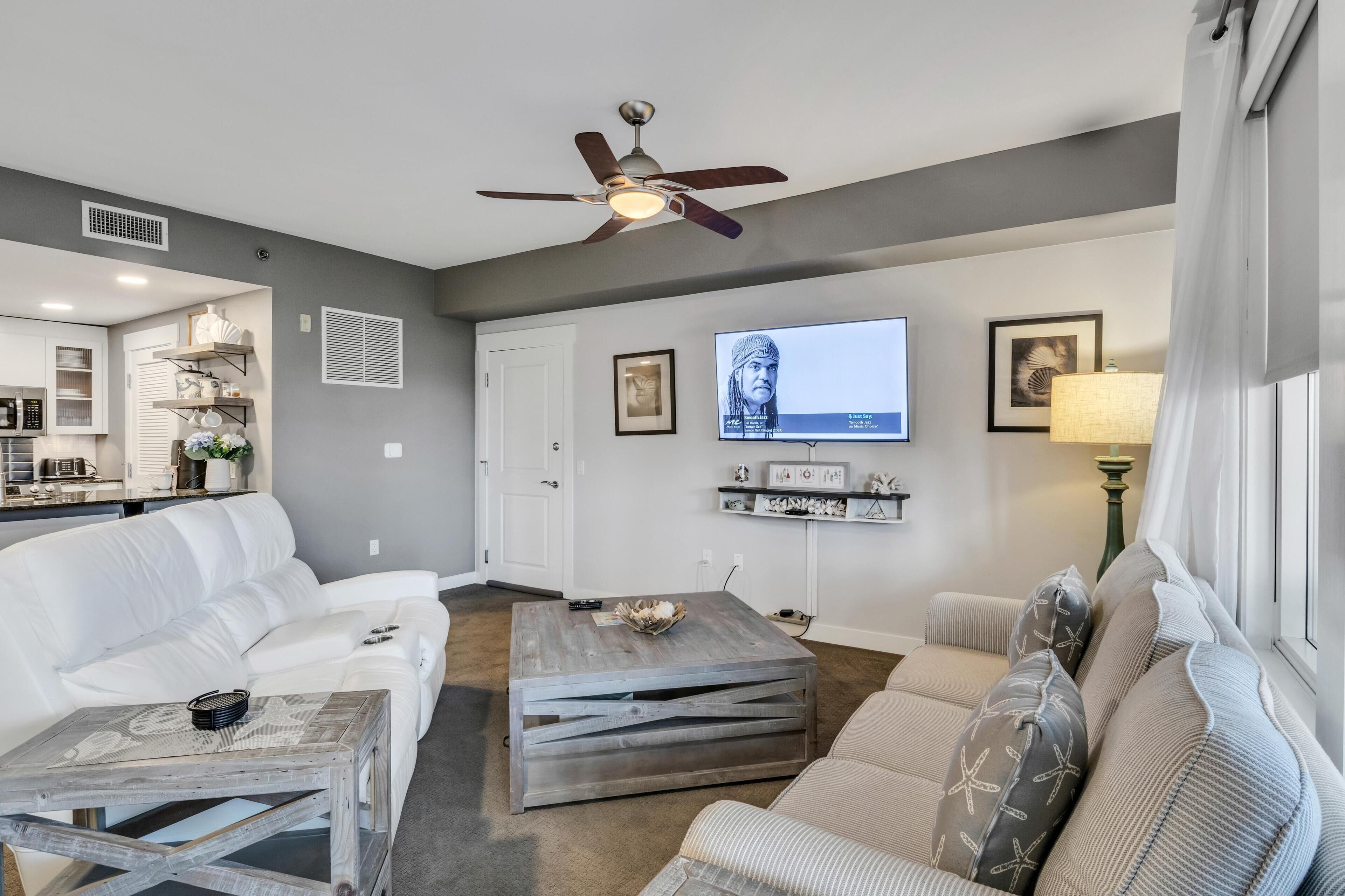A modern living room with a white sofa, a coffee table, and a television.