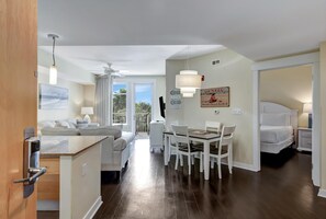 Enjoy a comfortable stay in this stylish room with a white bed, desk, and dining area, plus a kitchenette and window with a view.