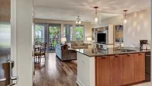 A modern kitchen with a central island, built-in appliances, and pendant lighting.