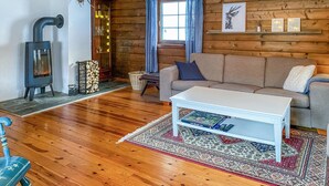 Ein gemütliches Wohnzimmer mit einer Couch, einem weißen Couchtisch, einem Kamin und Holzboden.
