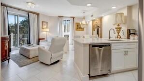 Una cocina moderna con armarios blancos, lavavajillas de acero inoxidable y encimera de mármol.