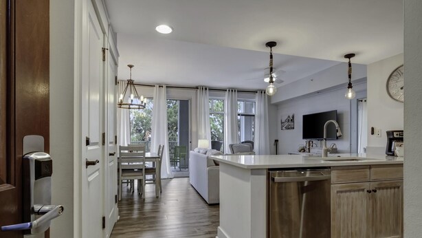 Una cocina moderna con una isla central, armarios de madera e iluminación colgante.