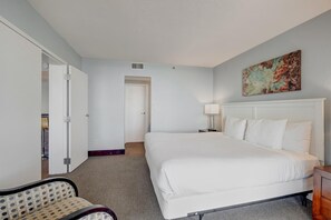 A hotel room with a large bed, a chair, a desk, and a painting on the wall. - Coastal Elegance - Revel in Our King Studio Sanctuary at Sandestin Golf and Beach Resort! (Miramar Beach)