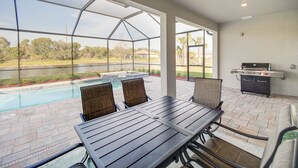 A patio area with a pool, a grill, and a table with chairs. - Alva Vacation Rental w/ Pool & Golf Course Access! (Alva)