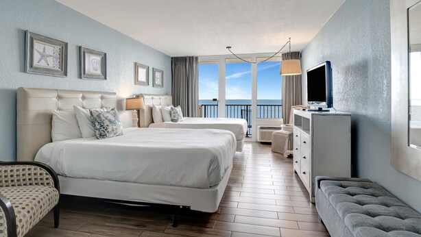 A hotel room with two beds, a television, a dresser, and a view of the sea. - Tranquil Studio with Resort Views in Bayside at Sandestin - Perfect for Four at Sandestin Golf and Beach Resort! (Miramar Beach)