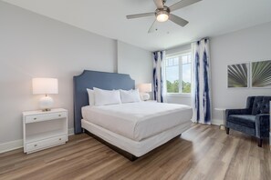 Relax in a serene space with a large bed, bedside tables, and a comfortable armchair.