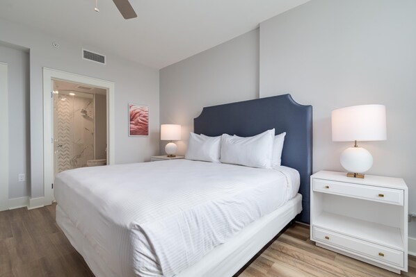 Restful retreat with a large bed, bedside tables, and a door leading to a bathroom.