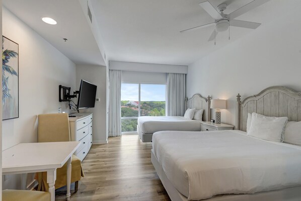 A hotel room with two beds, a desk, a chair, a TV, and a ceiling fan. - Versatile 6th Floor Studio: Pool & Gulf Views, King Bed, Sleeps 4 at Sandestin Golf and Beach Resort! (Miramar Beach)