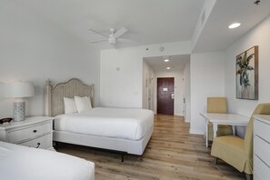 A hotel room with a large bed, a bedside table with a lamp, a chair, a desk, and a ceiling fan. - Versatile 6th Floor Studio: Pool & Gulf Views, King Bed, Sleeps 4 at Sandestin Golf and Beach Resort! (Miramar Beach)