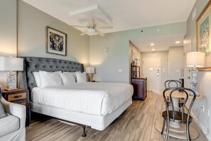 A bedroom with a large bed, bedside tables, a ceiling fan, and a dining area with chairs. - Spectacular Views: King Bed, Sleeper Sofa, Kitchenette, Sleeps 4 at Sandestin Golf and Beach Resort! (Miramar Beach)