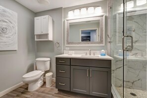 A modern bathroom with a toilet, vanity, and a glass shower enclosure. - Spectacular Views: King Bed, Sleeper Sofa, Kitchenette, Sleeps 4 at Sandestin Golf and Beach Resort! (Miramar Beach)