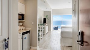 Een moderne keuken met witte kastjes en uitzicht op zee.