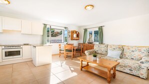 A compact living space with a kitchenette, dining area, and a sofa. - Villa Alma del Mar - Exceptional Villa with Marina Views & Pool (Minorca)