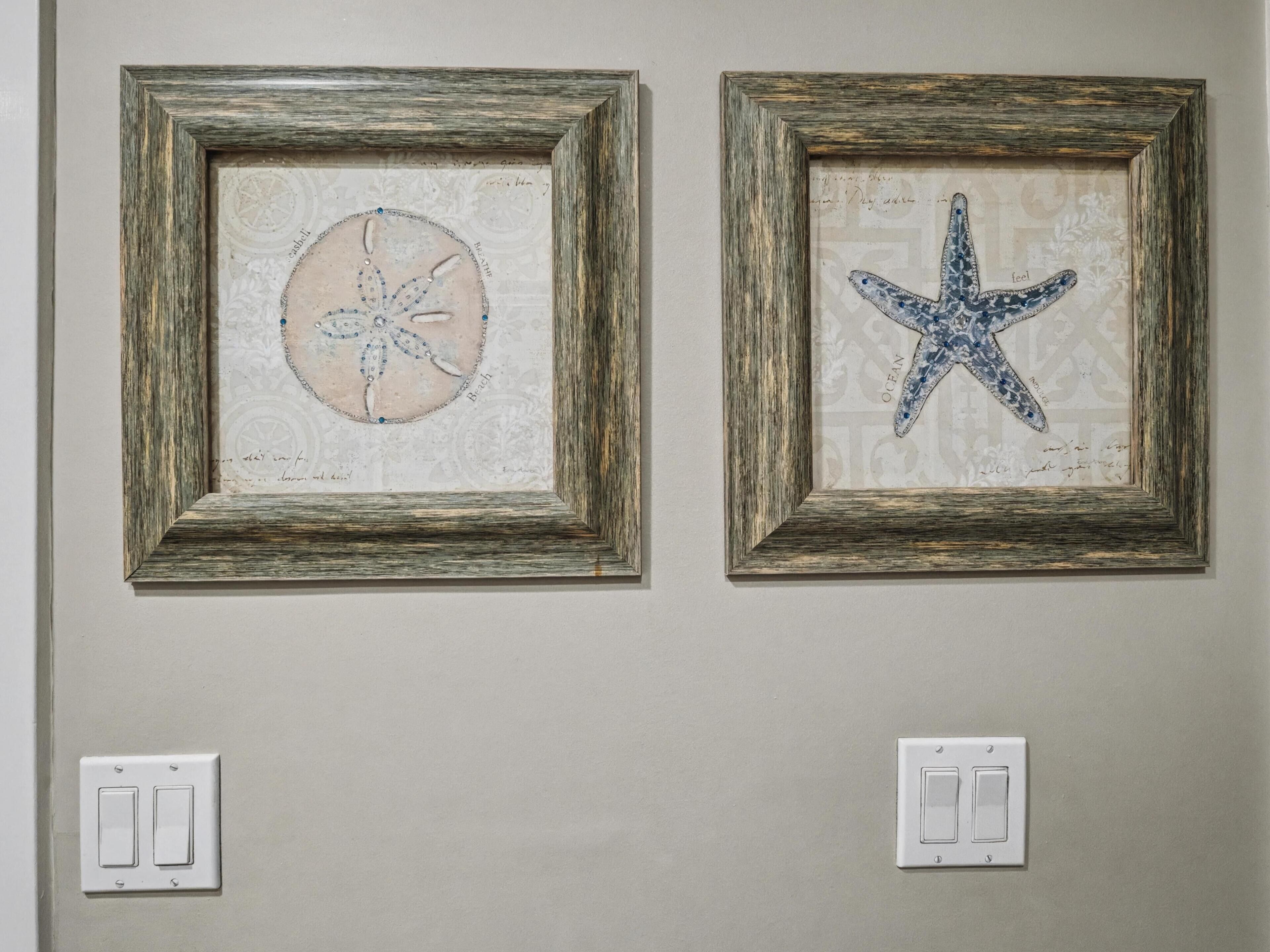 Two framed starfish artwork on a wall, each with a switch below.