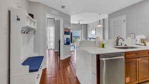 Una cocina moderna con lavavajillas, armarios de madera y encimera de mármol.