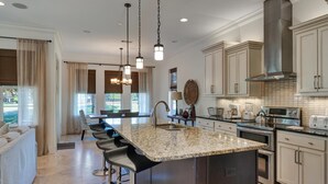 A modern kitchen with a large island, stainless steel appliances, and pendant lighting. - Sandestin 4BR/3.5BA Luxury Home: Gourmet Kitchen, Golf Cart, Sleeps 10 (Miramar Beach)