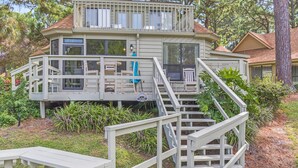A two-story house with a deck, outdoor furniture, and a staircase leading to the upper level. - Charming 3BR/3BA Sandestin Home: Spacious Comfort, Golf Cart, Sleeps 6 (Miramar Beach)