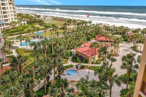 Ein Resort mit Pool, Palmen und Blick auf den Ozean.